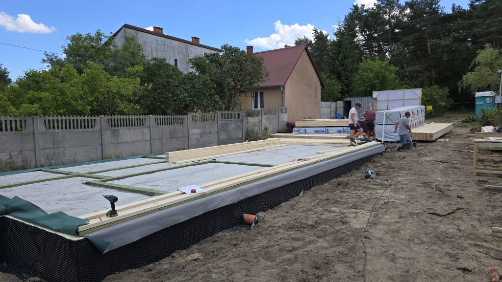 Podwaliny na fundamencie i przygotowanie drewnianych elementów ścian domu szkieletowego.